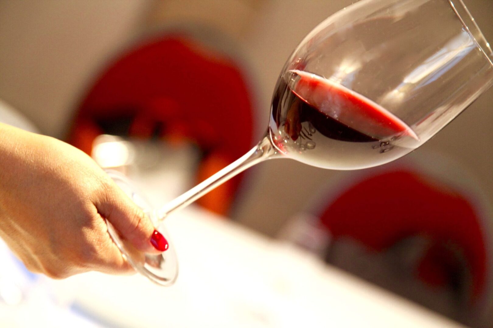 Main tenant verre de vin rouge pour identifier les couleurs et nuances d'un vin